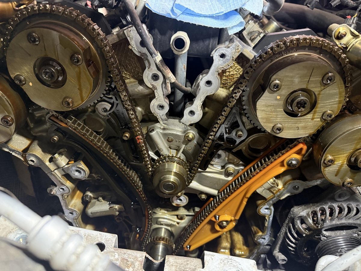 Close-up of exposed timing chains and cam phasers during a timing job