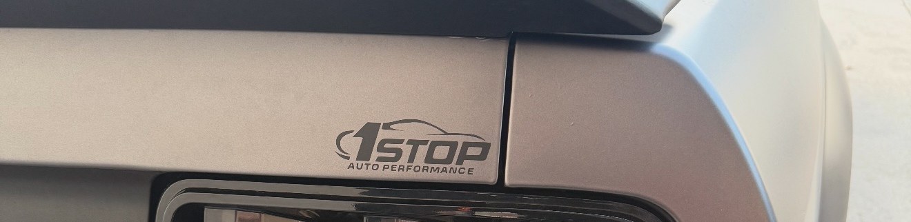 Black 1Stop Auto Performance decal on the matte grey wrapped rear panel of a Mustang, just above the taillight
